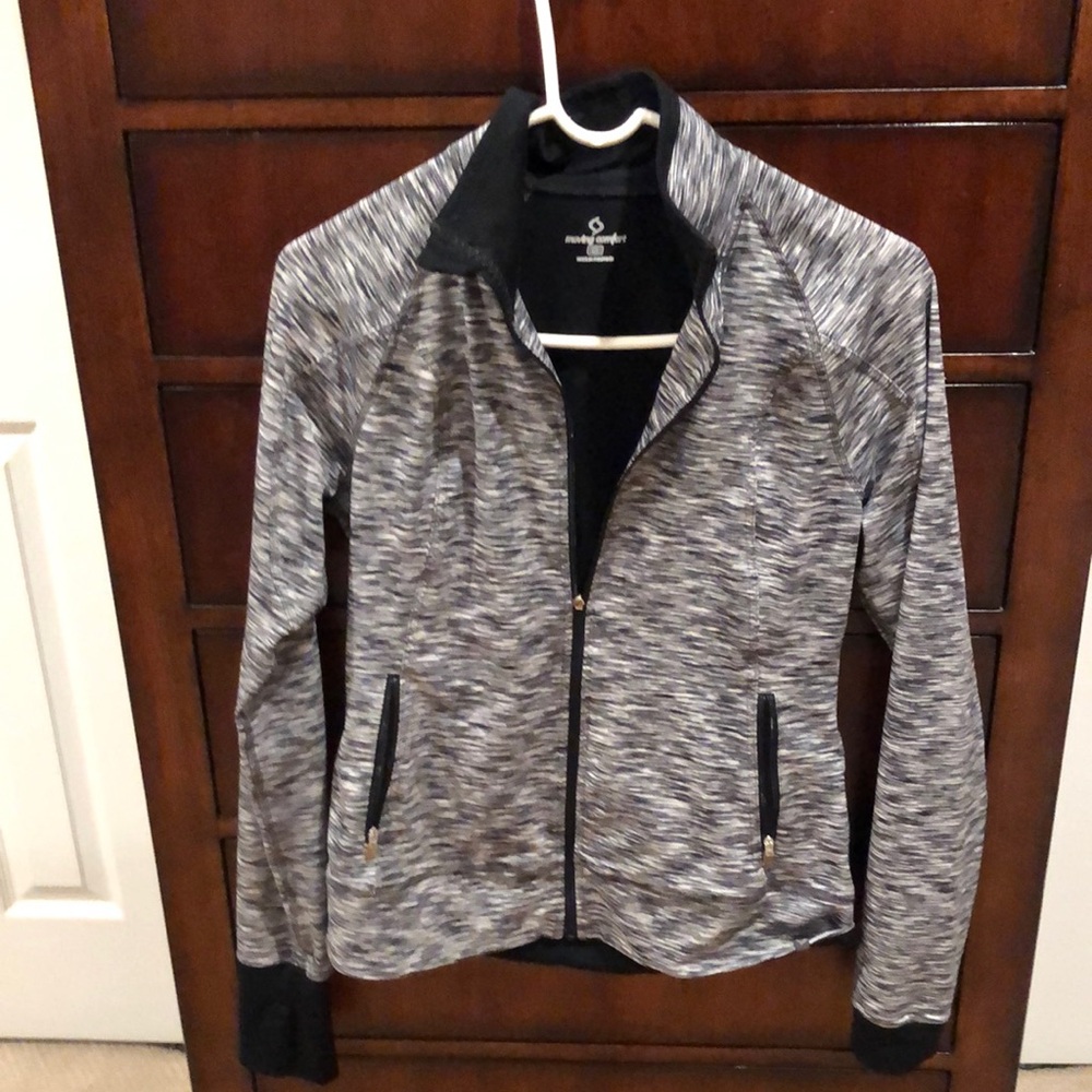 Exercise jacket with thumb holes in cuff and two zip pockets.